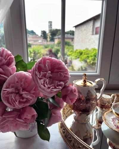 a vase with pink flowers on a table next to a window at B&B Corte Seguini in Bagnatica