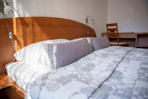 a bedroom with a bed with a wooden headboard at B&B Brezov Gaj in Kranjska Gora