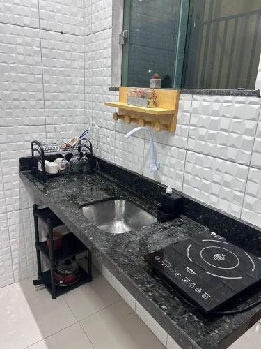 a bathroom counter with a sink and a stove at Apartamento em Alter do chão 2 quartos in Santarém