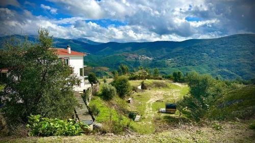 a house on a hill with mountains in the background at Alcmaria studio with amazing views! in Folhadosa
