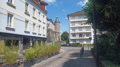 a street in a town with buildings and a tower at Résidence Le Château in Montbéliard