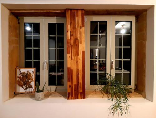 Cette chambre dispose de portes-fenêtres. dans l'établissement Maison médiévale Beaujolaise 17e siècle Authenticité Calme, à Jarnioux