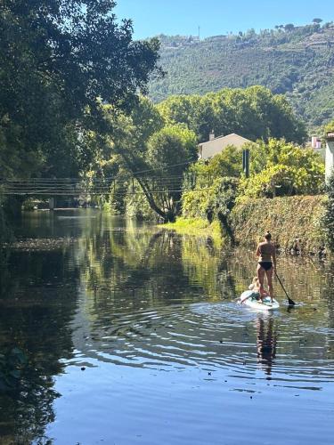 a man and a child on a paddle board in the water at Alcmaria studio with amazing views! in Folhadosa