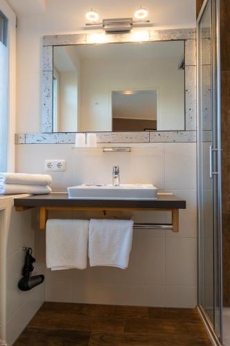 a bathroom with a sink and a mirror at Hotel Bichlhof in Reit im Winkl