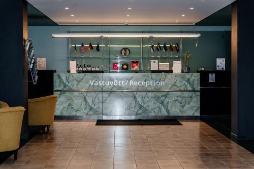 a restaurant with a counter in a room at Pärnu Hotel in Pärnu