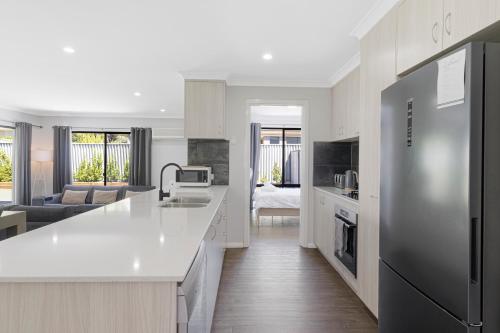 a kitchen with a refrigerator and a living room at 5 Bedroom Home meters from the beach in Geographe