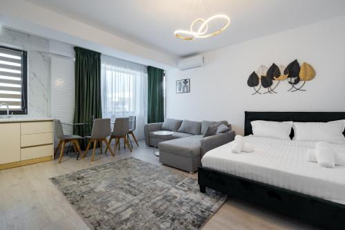 Un dormitorio con una cama, un sofá y una mesa. en Residence 5 Studio, en Voluntari