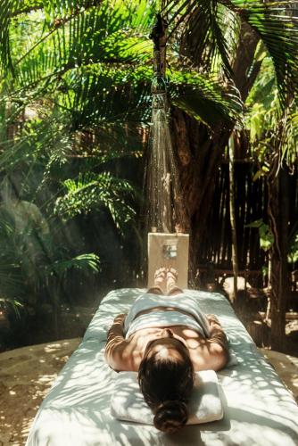 a man laying on a bed with a book at Viceroy Riviera Maya, a Luxury Villa Resort - Adults Only in Playa del Carmen