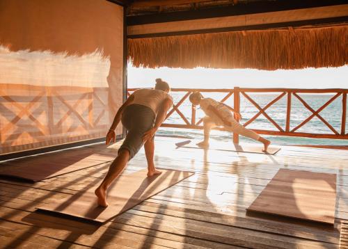 two people are doing yoga in a room at Viceroy Riviera Maya, a Luxury Villa Resort - Adults Only in Playa del Carmen