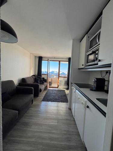un salon avec un canapé et une cuisine dans l'établissement Logement Avoriaz T2 vue magnifique La Falaise, à Avoriaz