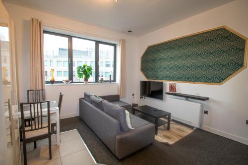 a living room with a couch and a table at Ideal for groups - Lovely 2 Bedroom Apartment - Free Parking, Transit links, Close to Stadiums in Manchester