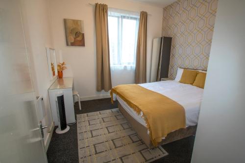 a hotel room with a bed and a window at Ideal for groups - Lovely 2 Bedroom Apartment - Free Parking, Transit links, Close to Stadiums in Manchester