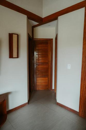 an empty hallway with a wooden door in a house at Jaguaríndia Village in Fortim