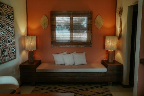 a bed in a room with two lamps at Jaguaríndia Village in Fortim