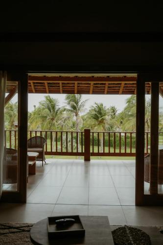 a living room with a view of the palm trees at Jaguaríndia Village in Fortim