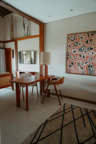 a living room with a table and a painting on the wall at Jaguaríndia Village in Fortim