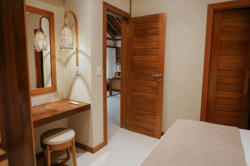 a bedroom with a bed and a desk and a mirror at Jaguaríndia Village in Fortim