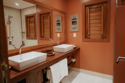 a bathroom with two sinks and a mirror at Jaguaríndia Village in Fortim