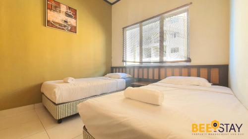 a bedroom with two beds and a window at Gold Coast Morib Studio l Apartment I Penthouse in Banting