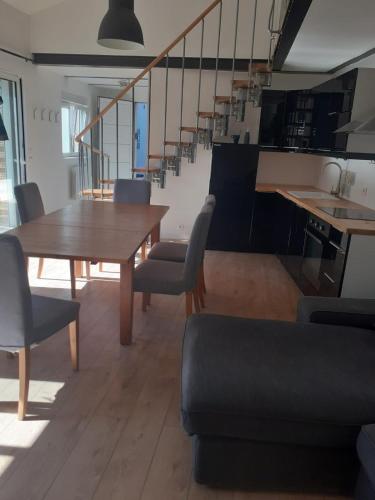 une salle à manger avec une table et des chaises et des escaliers dans l'établissement Chez Polo, à Saint-Denis