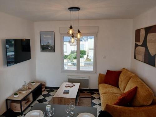 un salon avec un canapé et une table dans l'établissement La Maison de la plage, à Hauteville-sur-Mer