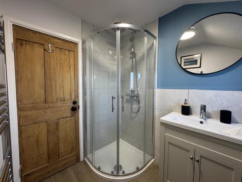 Un baño con ducha, lavabo y espejo. en Driftwood House - Luxury Dog-Friendly Townhouse in Cowes, Steps from Marina, en Cowes
