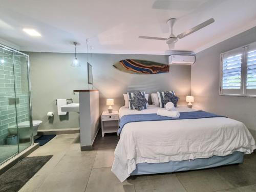 a bedroom with a large bed and a bathroom at Beachfront Bliss in Ballito