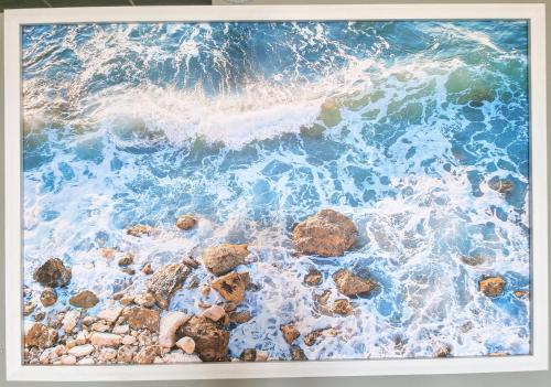 a painting of the ocean with rocks and waves at Beachfront Bliss in Ballito