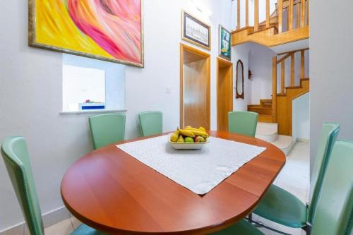 a dining room with a wooden table with a bowl of bananas on it at Peaceful Villa near Dubrovnik in Trsteno