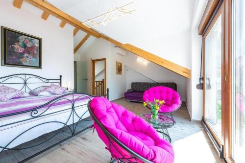 a bedroom with pink chairs and a bed at Peaceful Villa near Dubrovnik in Trsteno