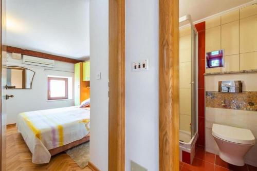 a bedroom with a bed and a bathroom with a toilet at Peaceful Villa near Dubrovnik in Trsteno