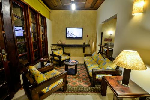 
a living room filled with furniture and a tv at Estalagem Casa Grande Pousada in Ubatuba
