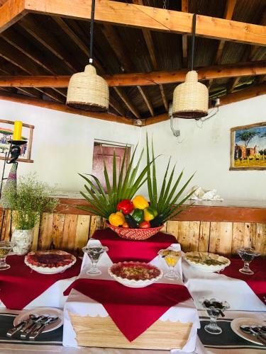 a table with red table cloths and a bowl of food at Mara Sweet Acacia Lodge in Talek