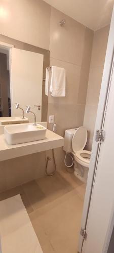 a bathroom with a sink and a toilet at Loft casa 203 COND BRISAS DO FAROL n 07 in Salvador