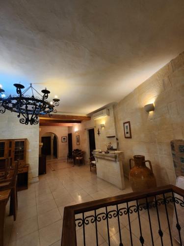 a large kitchen and living room with a chandelier at Poolside Paradise, Private comfort, stunning views, and effortless self checkin in Għajn il-Kbira