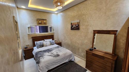 a bedroom with a bed and a dresser and a mirror at Quadra Sphere in Tamraght Ouzdar
