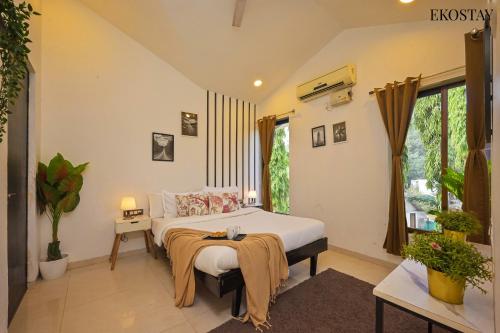 a bedroom with a bed and a large window at EKOSTAY - Water Lagoon in Lonavala