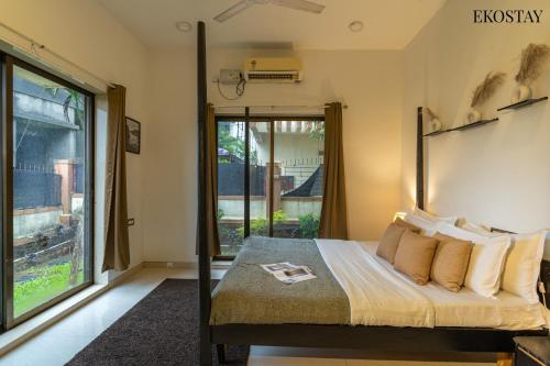 a bedroom with a bed and a large window at EKOSTAY - Water Lagoon in Lonavala