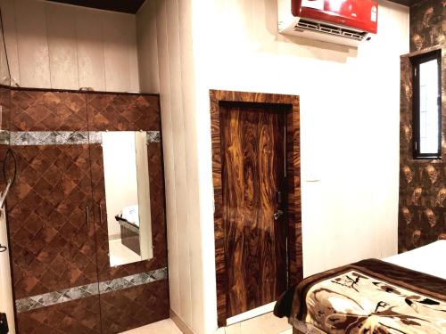 a room with a bed and a bathroom with a mirror at Shri Banke Bihari Seva Sadan Vrindavan in Vrindāvan
