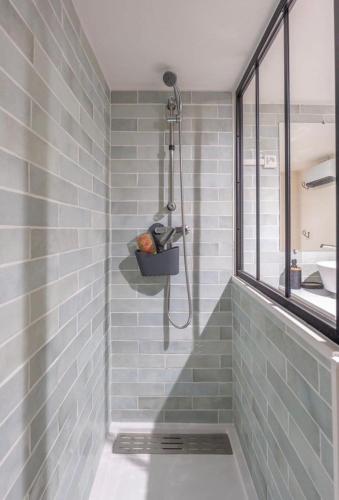 une salle de bain avec douche aux carreaux bleus dans l'établissement Chez Seb - Raffiné et Accueillant, à Carcassonne