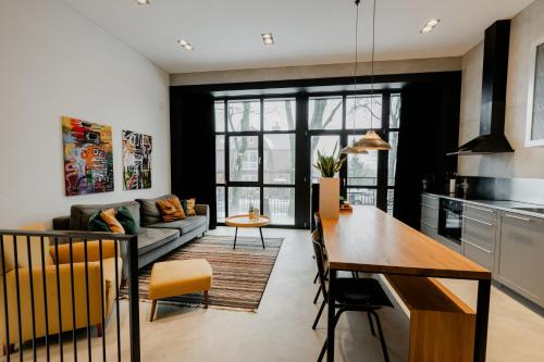 a kitchen and living room with a couch and a table at Modern and spacious loft type apartment 8 with free private parking by "Owl Jazz Apartments" in Kaunas