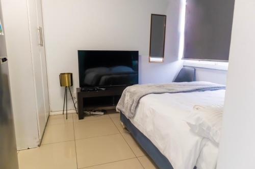 una camera da letto con un letto e una TV a schermo piatto di Modern apartments at CZ KUBS a East London