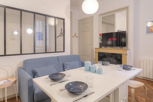 - un salon avec une table, des chaises et une télévision dans l'établissement Cosy et Typique à Cordeliers, à Lyon