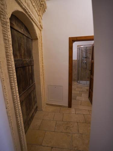 a hallway with a large wooden door and a tile floor at Due forni affittacamere in Matera