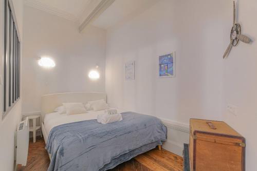 une chambre blanche avec un lit et un parquet dans l'établissement Cosy et Typique à Cordeliers, à Lyon