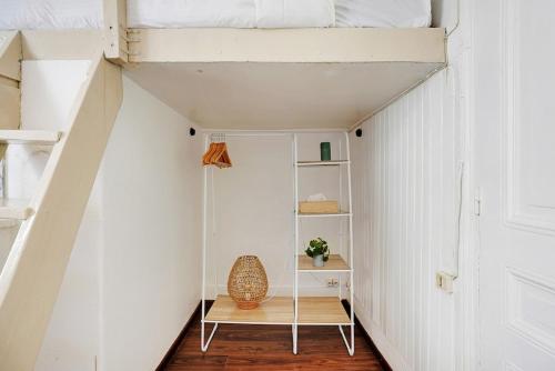 une chambre avec une étagère et un mur blanc dans l'établissement Charming flat with Terrace in Batignolles - PARIS, à Paris