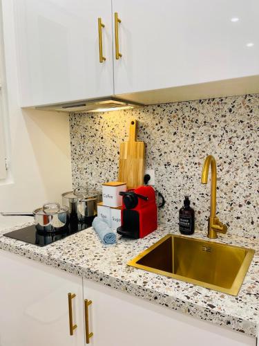 - un comptoir de cuisine avec un évier et un comptoir dans l'établissement Chic Apartment Arc de Triomphe-Champs Élysées, à Paris
