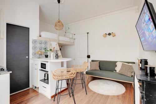 un petit salon avec un canapé et une cuisine dans l'établissement Charming flat with Terrace in Batignolles - PARIS, à Paris