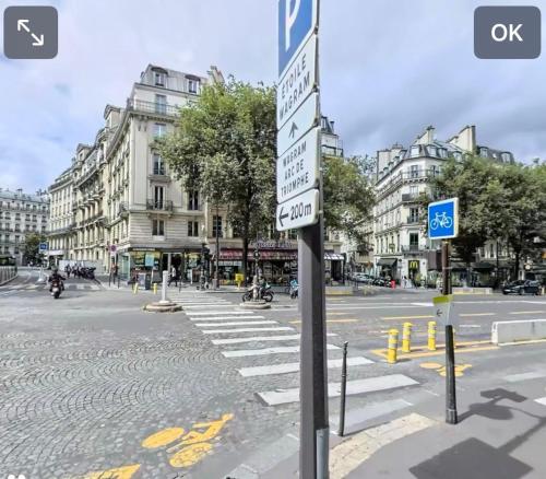 a street sign in the middle of a city street at Chic Apartment Arc de Triomphe-Champs Élysées in Paris