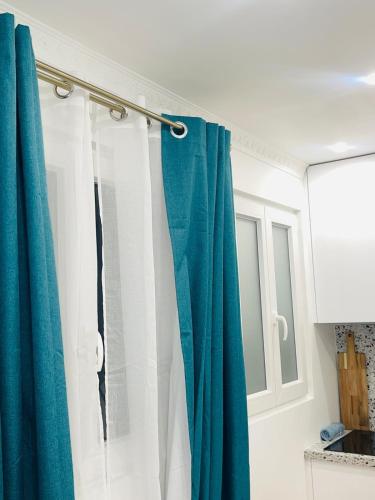 La salle de bains est pourvue d'un rideau de douche bleu et blanc. dans l'établissement Chic Apartment Arc de Triomphe-Champs Élysées, à Paris